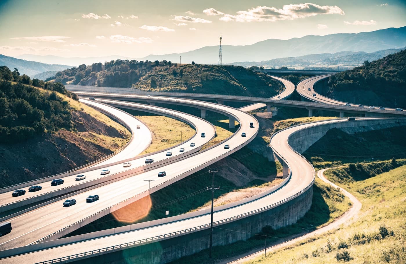 Sweeping multi-level motorway interchange carrying traffic through hills